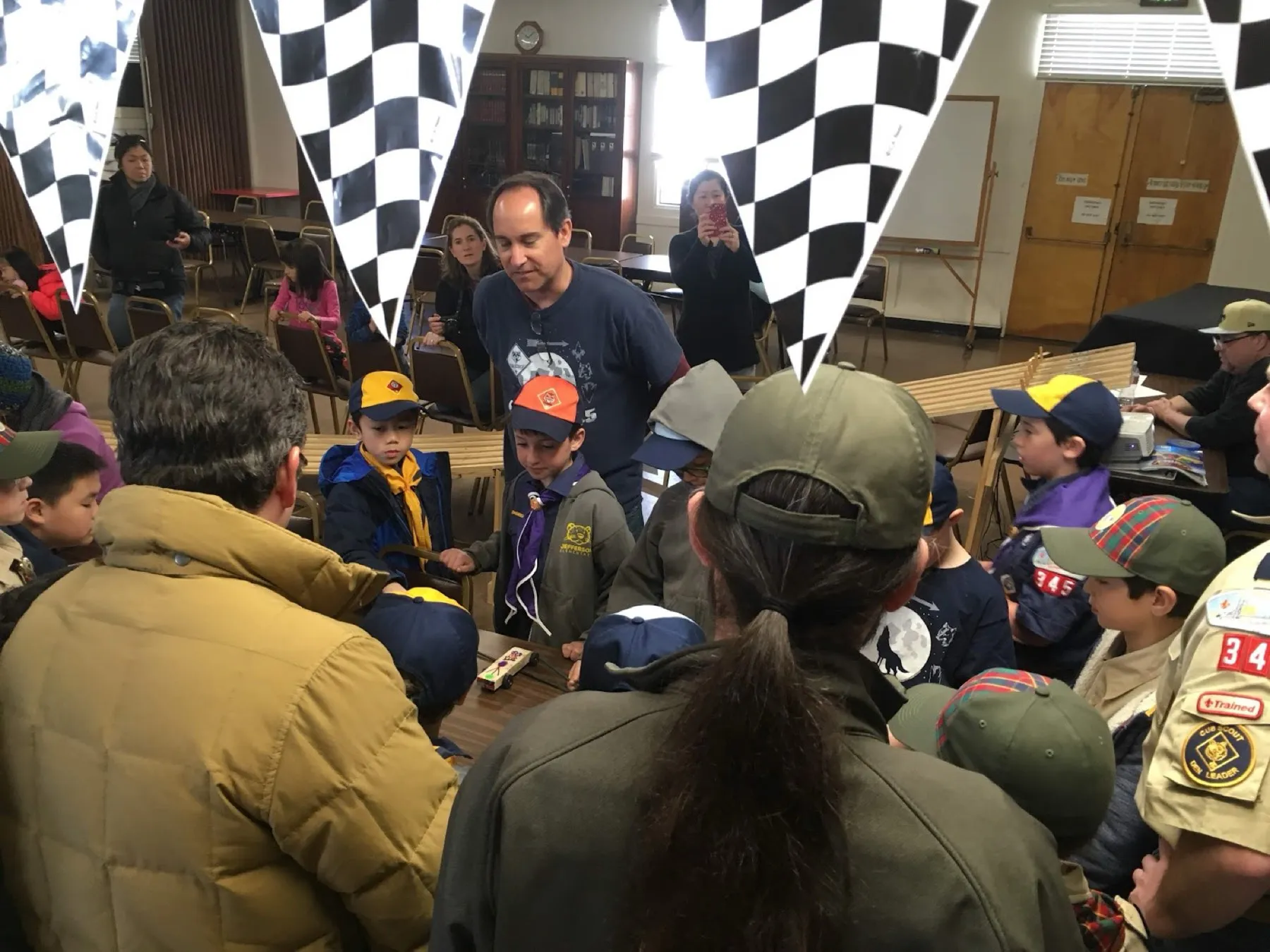 Scouts gathered around the Pinewood Derby track